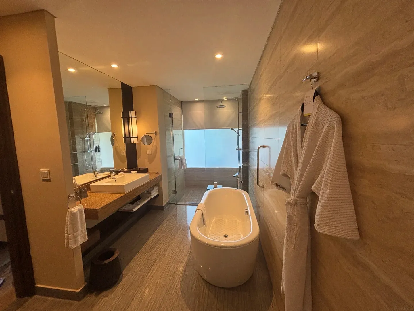 A Westin bathroom with a freestanding tub, a glass shower and a robe on the wall