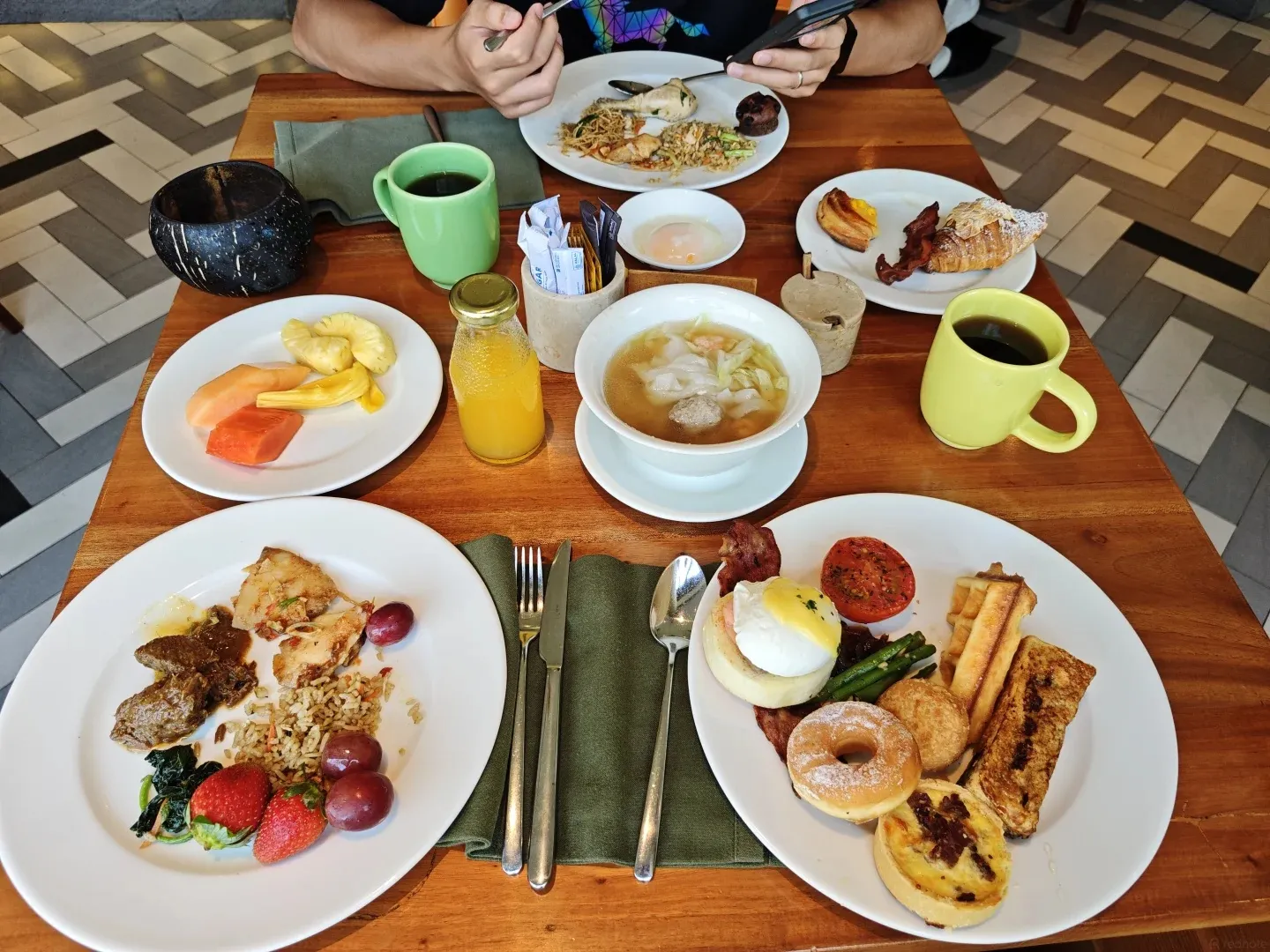 Breakfast plates of eggs, noodles, pastries and fruit on the terrace