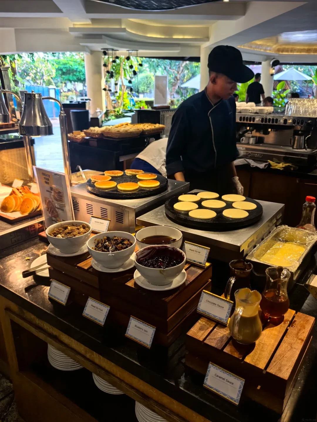 A cook making pancakes at the breakfast buffet