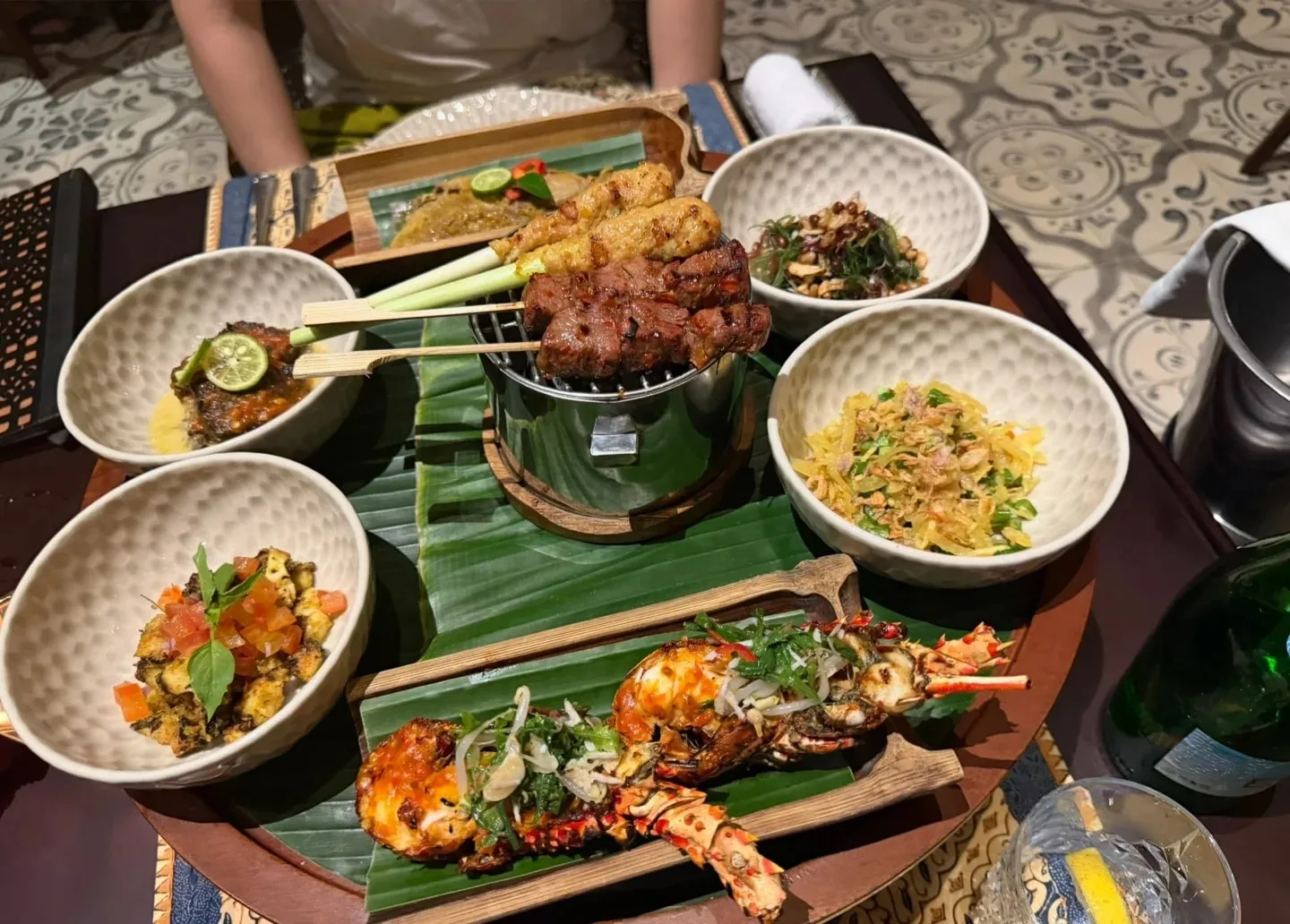 Satay, grilled prawns and Balinese dishes spread across a dinner table