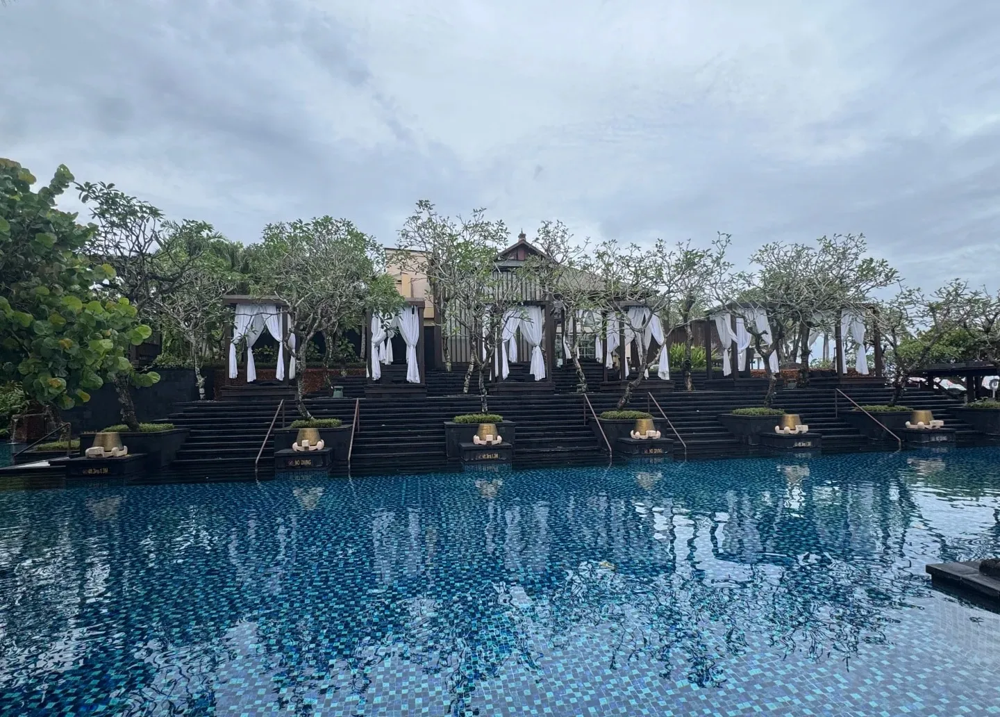 Thatched pavilions reflected in the lagoon pool at the St. Regis