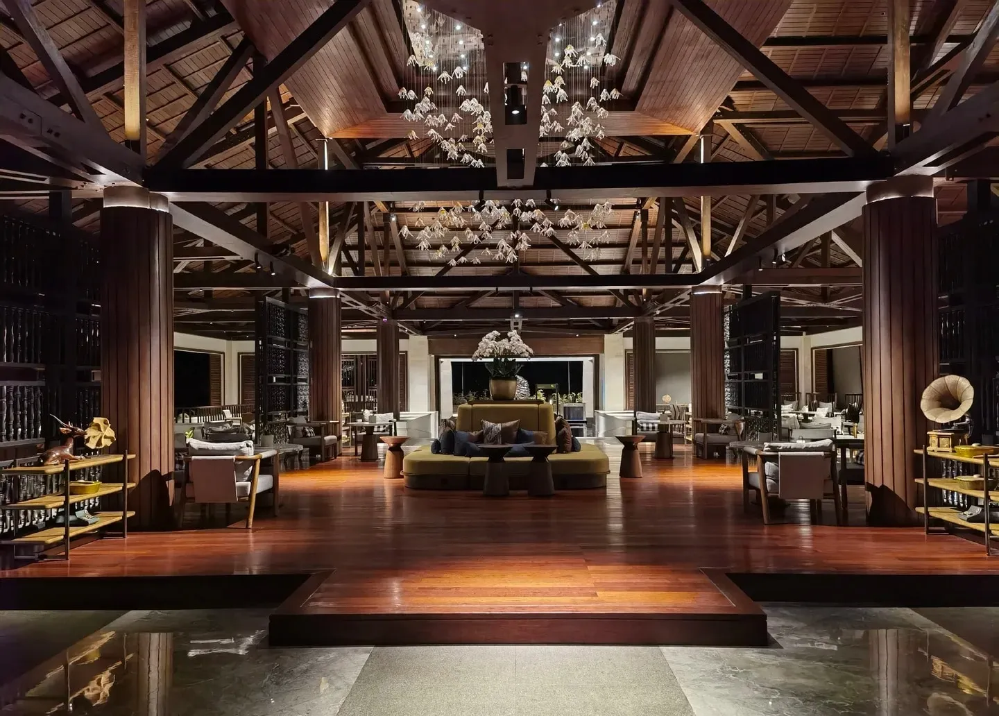 The open-sided lobby at night, under a soaring timber roof