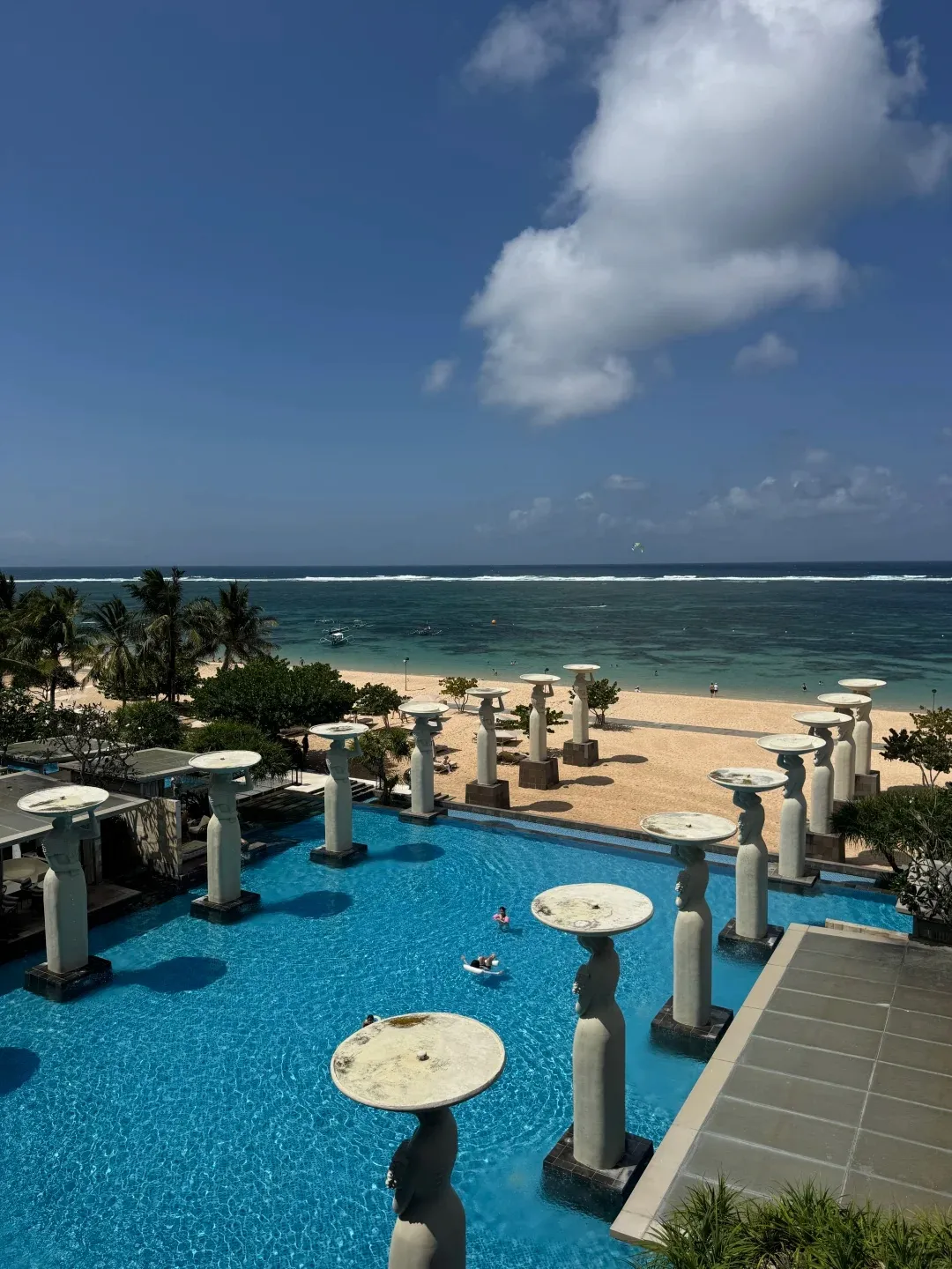 Sculpted columns rising from a pool just above the beach