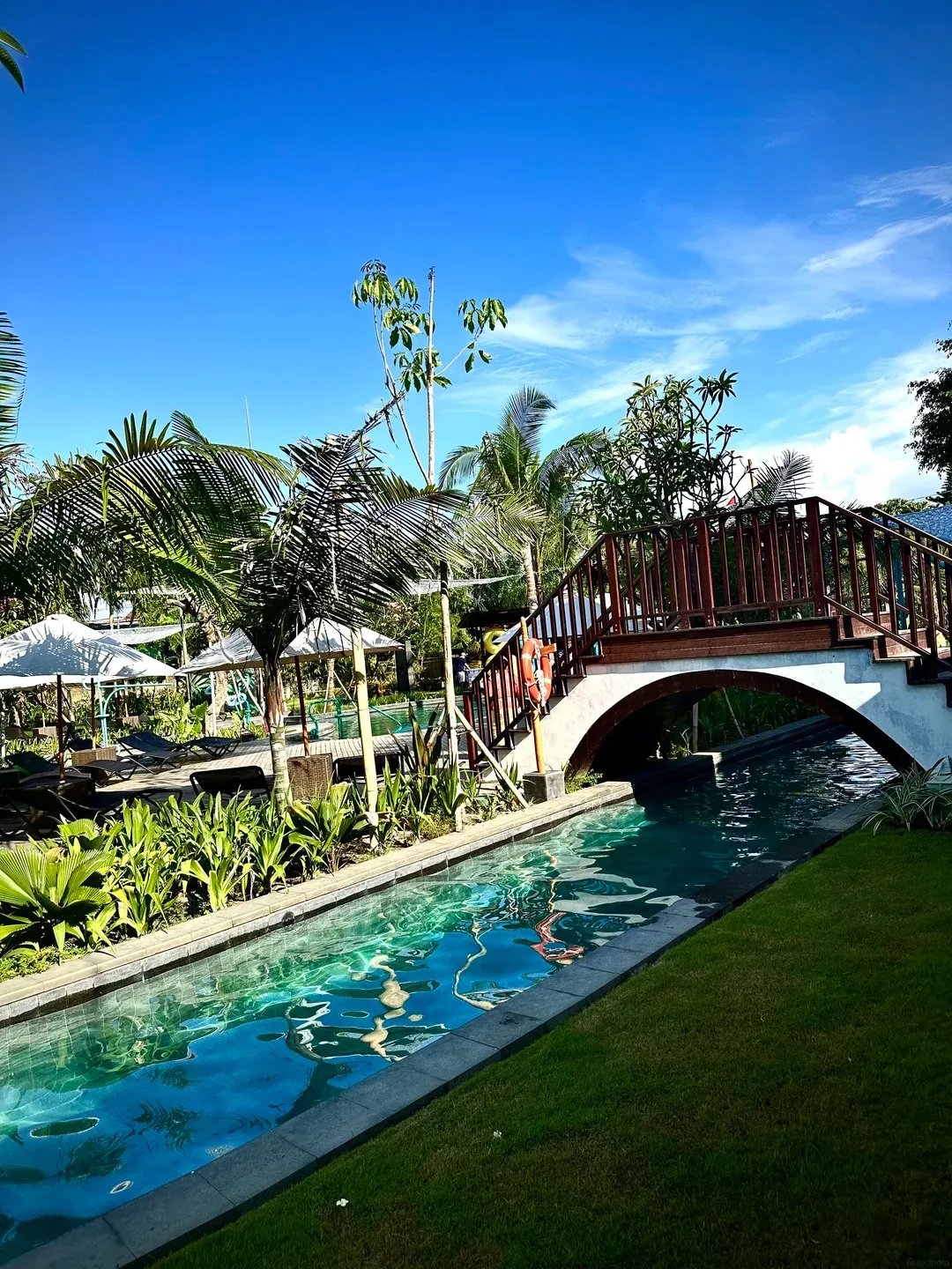 A timber footbridge arching over a narrow pool