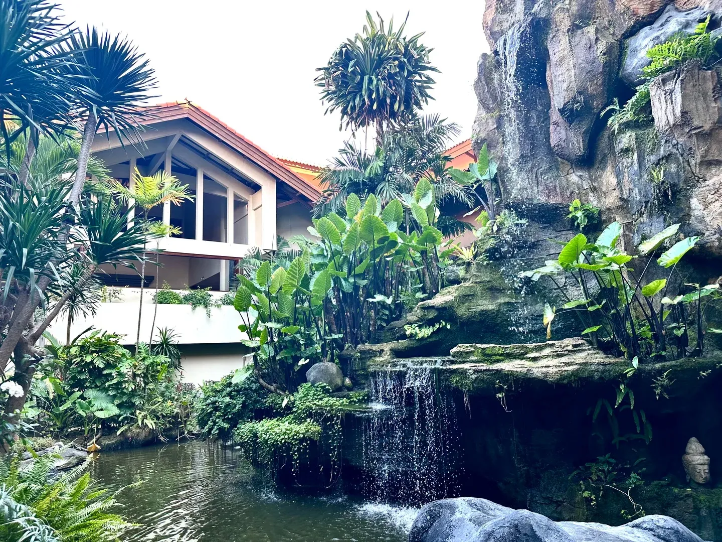 A rock waterfall spilling into a garden pond
